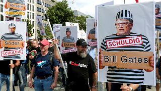La gente asiste a una protesta en Berlín, Alemania, el 29 de agosto de 2020 contra las restricciones del coronavirus. Un letrero con Bill Gates en el que se lee "Culpable".