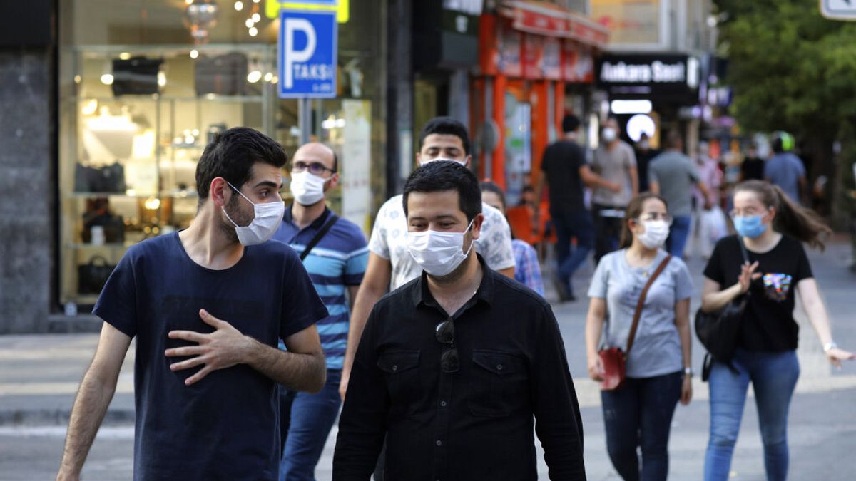 People wearing face masks to protect against the spread of coronavirus, walk in Ankara