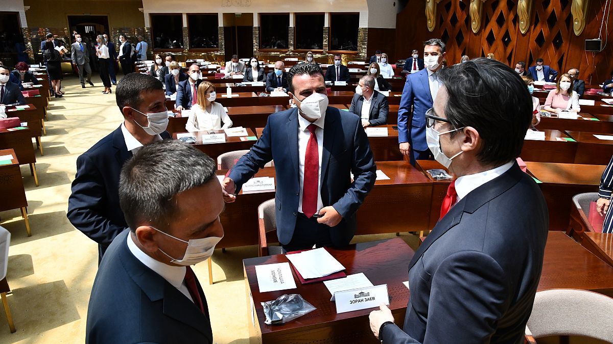 Zoran Zaev, the leader of the social democrats (SDSM), center, talks to the country's President Stevo Pendarovski, right, in parliament on Tuesday, Aug. 4, 2020 