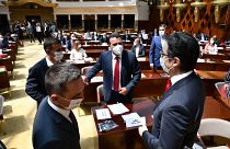 Zoran Zaev, the leader of the social democrats (SDSM), center, talks to the country's President Stevo Pendarovski, right, in parliament on Tuesday, Aug. 4, 2020