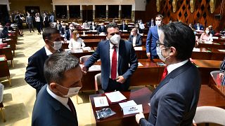 Zoran Zaev, the leader of the social democrats (SDSM), center, talks to the country's President Stevo Pendarovski, right, in parliament on Tuesday, Aug. 4, 2020 