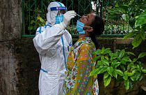 An Indian health worker takes a nasal swab sample to test for COVID-19 during a door to door test drive in Gauhati, India, Saturday, Aug. 29, 2020