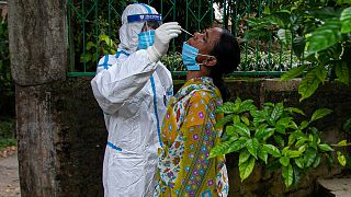 An Indian health worker takes a nasal swab sample to test for COVID-19 during a door to door test drive in Gauhati, India, Saturday, Aug. 29, 2020