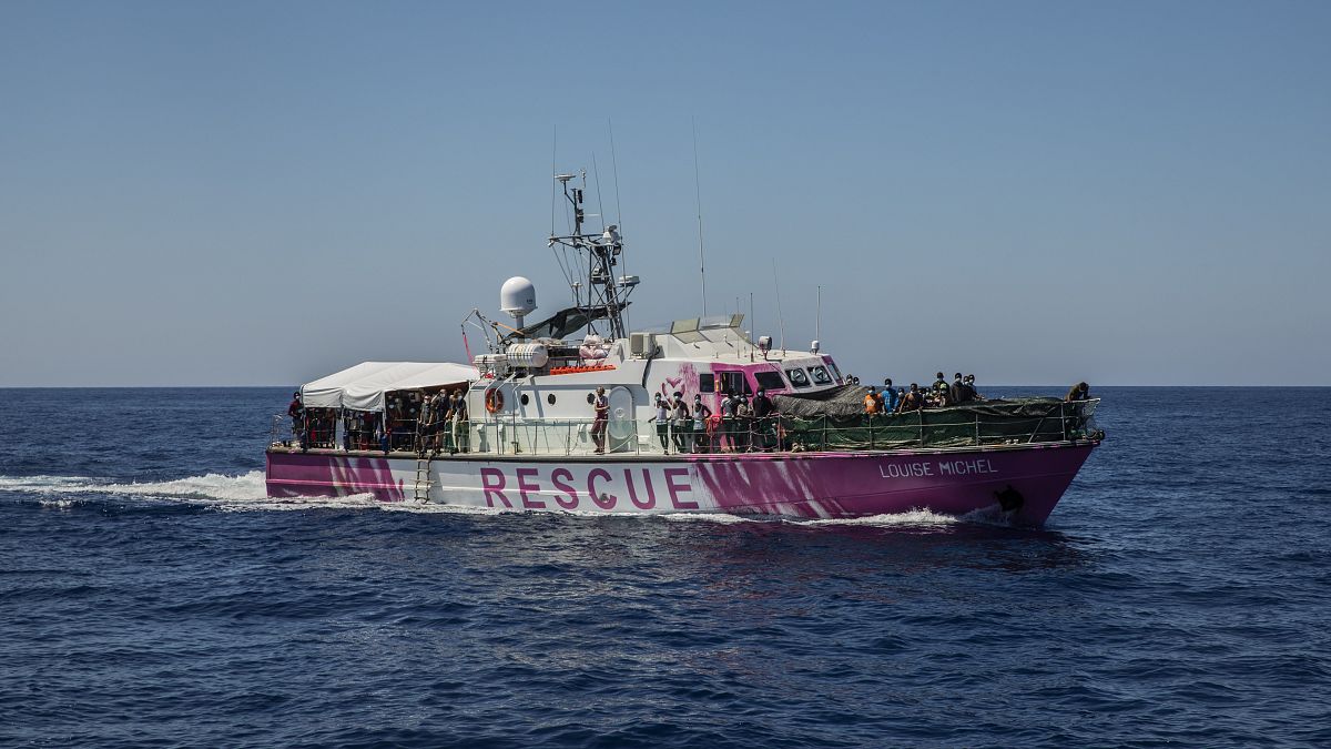 Migrantes a bordo do "Louise Michel" em terra firme