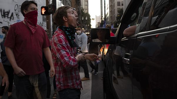 A Black L:ives Matter protester yells at a supporter of President Donald Trump during a rally and car parade. A Black L:ives Matter protester yells at a supporter of President Donald Trump during a rally and car parade.