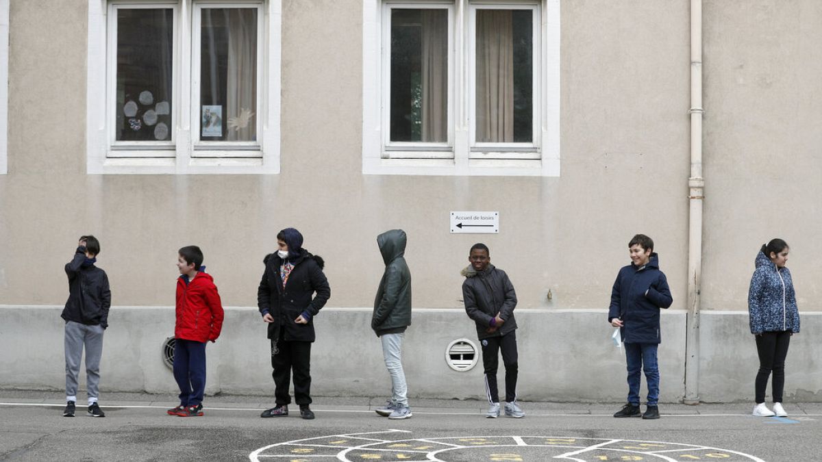 In this Thursday, May 14, 2020 file photo, schoolchildren wait in line to go back in their classroom at the Sainte Aurelie primary school of Strasbourg.
