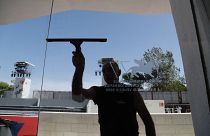 A worker cleans a glass door of the Cinema Palace at the Venice Lido, Sunday, Aug. 30, 2020.