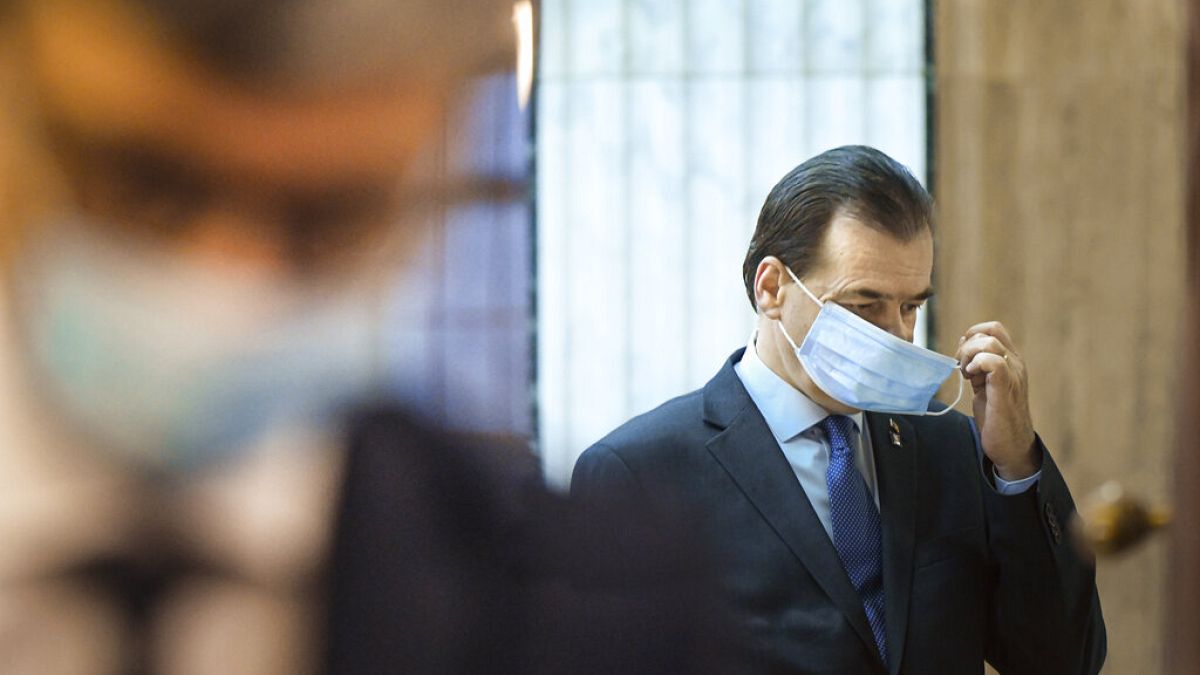  In this May 14, 2020 file photo Romanian Prime Minister Ludovic Orban handles his face mask before attending a meeting ahead of the loosening of measures taken by the state.