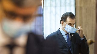  In this May 14, 2020 file photo Romanian Prime Minister Ludovic Orban handles his face mask before attending a meeting ahead of the loosening of measures taken by the state.