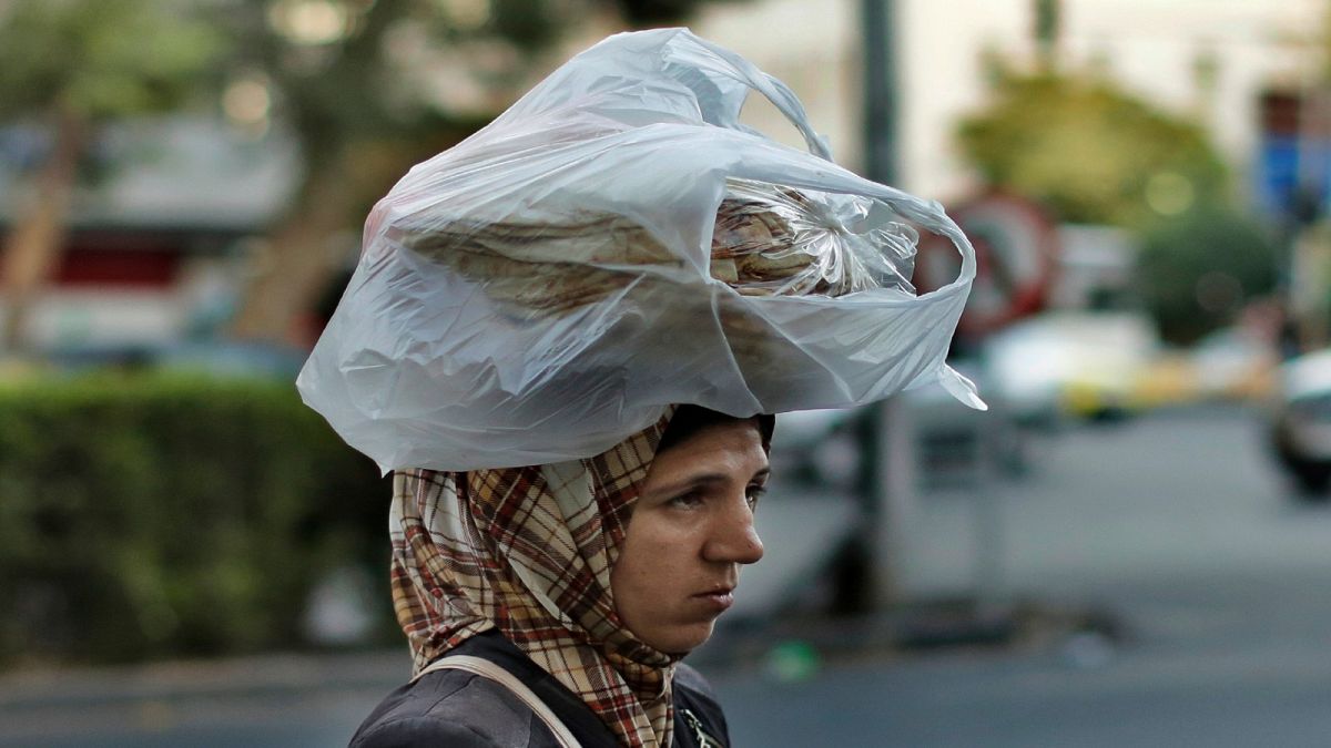 مواطنة سورية في العاصمة دمشق تحمل خبزاً على رأسها 