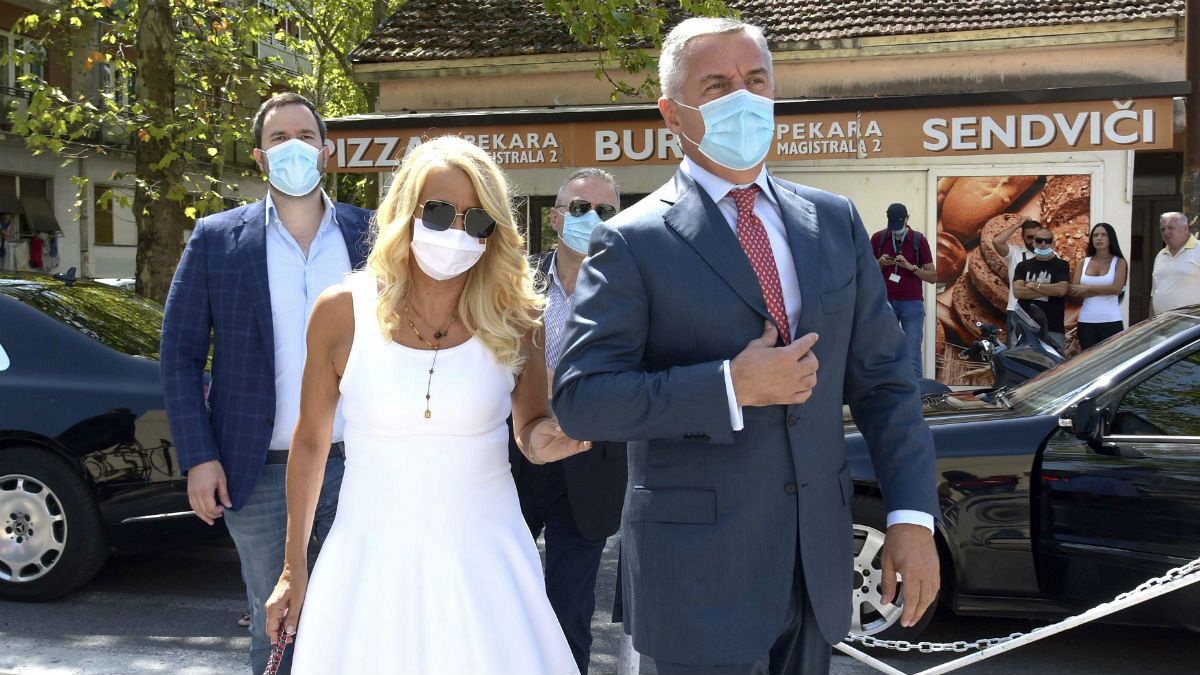 Montenegrin President Milo Djukanovic, wearing a mask, accompanied by his wife Lidija arrives at the polling station in Podgorica, Montenegro
