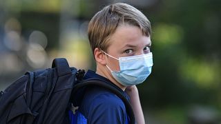 A child in Gelsenkirchen, Germany, returns to school wearing a mask. Wednesday, Aug. 12, 2020.