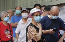 People wearing face masks queue for the coronavirus test outside a testing center in Hong Kong, Tuesday, Sept. 1, 2020.