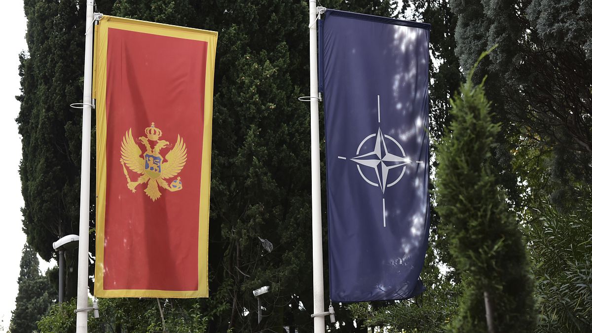 In this photo taken Monday, Nov. 11, 2019, the Montenegro, left, and NATO flags wave in front of the Montenegrin Defense Ministry in Podgorica, Montenegro.