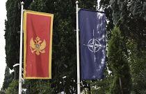 In this photo taken Monday, Nov. 11, 2019, the Montenegro, left, and NATO flags wave in front of the Montenegrin Defense Ministry in Podgorica, Montenegro.
