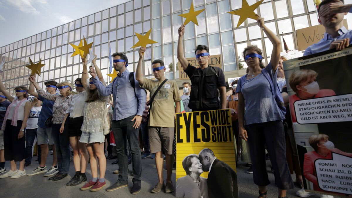 Protesters hold EU stars in front of the German Embassy in Sofia, Bulgaria, Wednesday, Aug. 12, 2020.