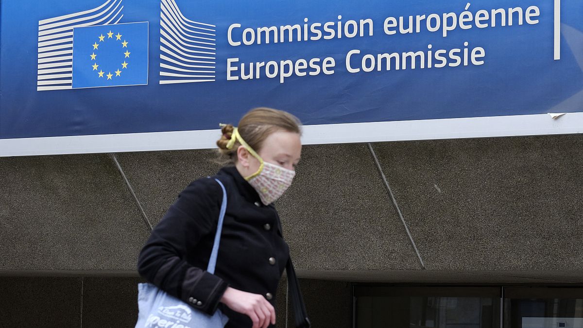 ARCHÍV: 2020. április 14. - védmaszkot viselő nő halad el az Európai Bizottság épülete előtt Brüsszelben