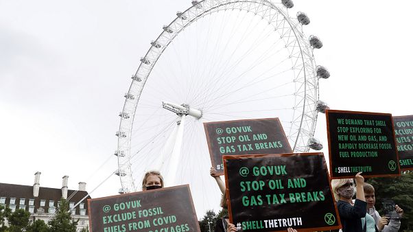 Extinction Rebellion climate change protesters and activists hold up placards in front of the London Eye. Friday, Aug. 28, 2020. Extinction Rebellion climate change protesters and activists hold up placards in front of the London Eye. Friday, Aug. 28, 2020.