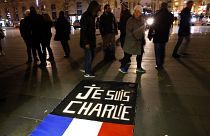 People walk around to banner reading "Je suis Charlie", "I am Charlie" on the Place de la Republique in Paris. January 7, 2016.