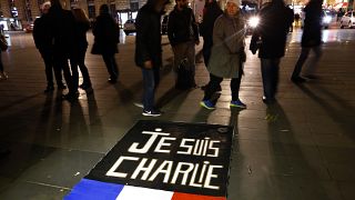 People walk around to banner reading "Je suis Charlie", "I am Charlie" on the Place de la Republique in Paris. January 7, 2016.