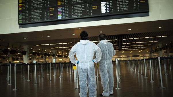 Utasok védőöltözékben a brüsszeli Zaventem repülőtéren Utasok védőöltözékben a brüsszeli Zaventem repülőtéren