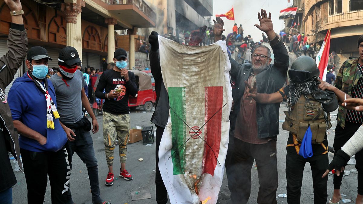 متظاهرون إيرانيون يحرقون العلم الإيراني  خلال مظاهرات -تشرين الثاني/نوفمبر 2019 