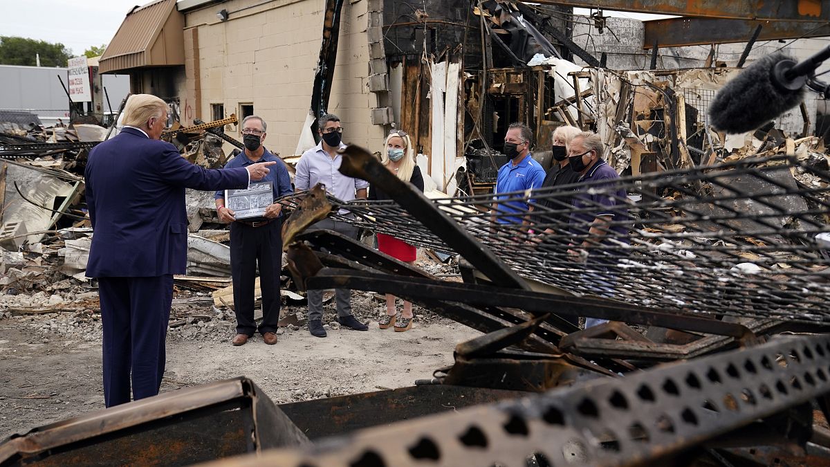 President Donald Trump talks to business owners Tuesday, Sept. 1, 2020, as he tours an area damaged during demonstrations after a police officer shot Jacob Blake in Kenosha.