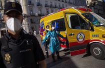 A health worker in personal protection equipment is disinfected by a another health worker at the Puerta del Sol in Madrid, Spain, Friday, Aug. 28, 2020.