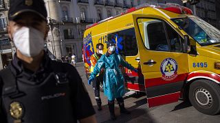 A health worker in personal protection equipment is disinfected by a another health worker at the Puerta del Sol in Madrid, Spain, Friday, Aug. 28, 2020.