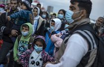 Refugees and migrants wearing masks to prevent the spread off the coronavirus, after their arrival at the port of Piraeus , near Athens, on May 4, 2020.