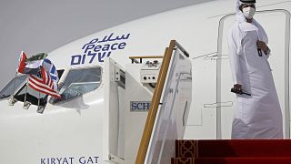 مسؤول إماراتي يقف عند باب طائرة لشركة "إل عال" الإسرائيلية بعد هبوطها في أبو ظبي، الإمارات العربية المتحدة.