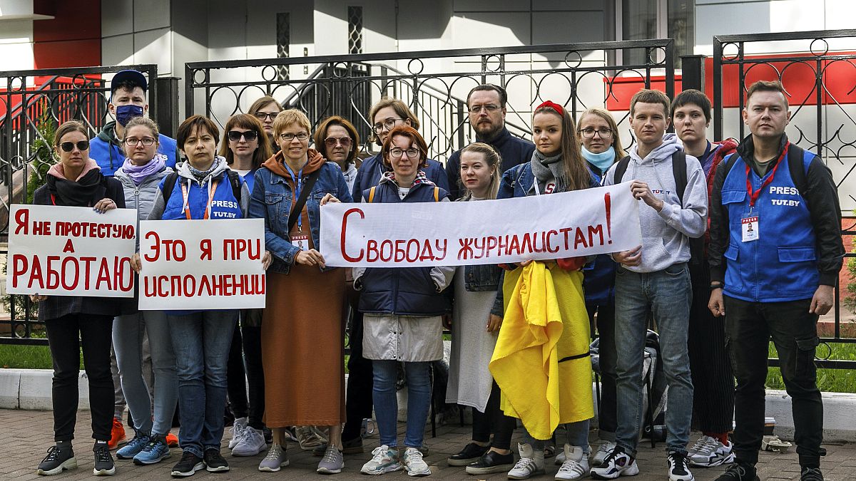 Journalists of Belarusian TUT.BY media outlet hold banners reading "I don't protest but work"and "Freedom for journalists!", outside a police station in Minsk, Sept. 2, 2020.