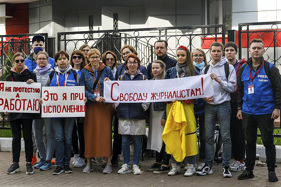 Journalists of Belarusian TUT.BY media outlet hold banners reading "I don't protest but work"and "Freedom for journalists!", outside a police station in Minsk, Sept. 2, 2020.