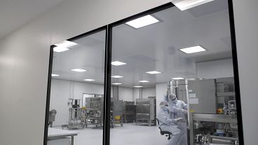 FILE - In this Aug. 14, 2020, file photo, laboratory technicians work on an experimental coronavirus vaccine.