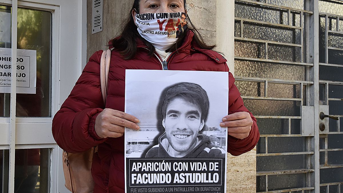 Cristina Castro, madre del joven muerto, muestra un cartel con su foto