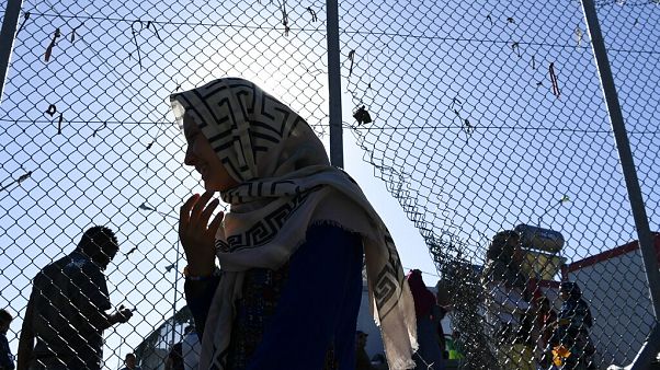 Μια γυναίκα βγαίνει από τον καταυλισμό της Μόριας Μια γυναίκα βγαίνει από τον καταυλισμό της Μόριας