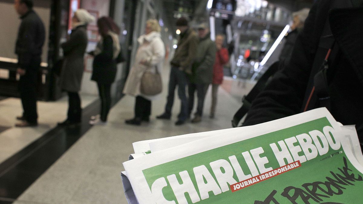 صورة من الأرشيف- يصطف الناس لشراء عدد من صحيفة شارلي إيبدو في كشك لبيع الصحف في باريس