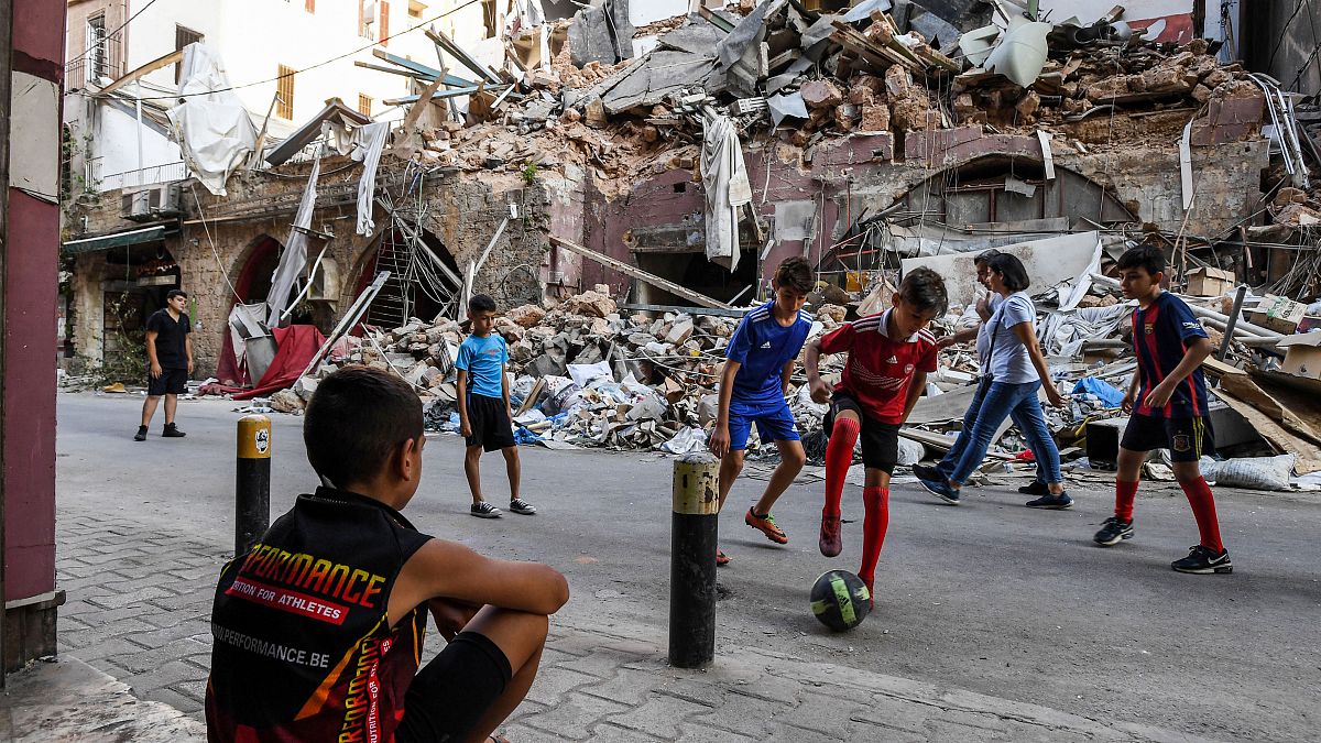 أطفال يلعبون أمام ركام أحد الأبنية المهدمة في بيروت