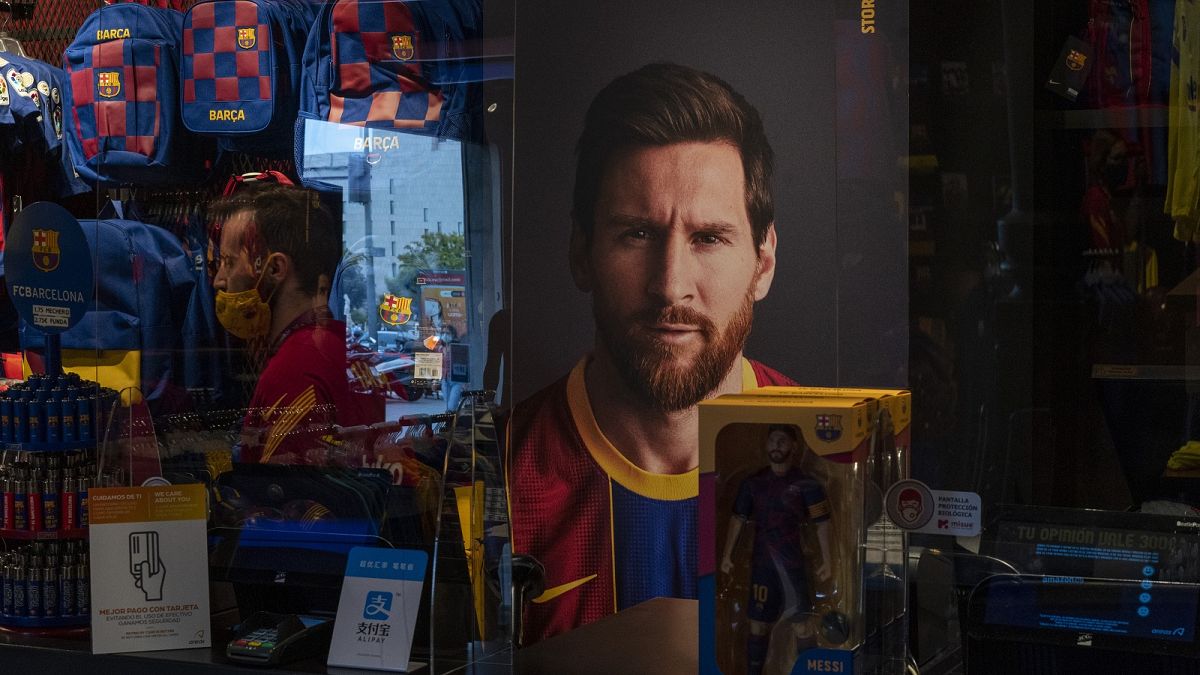 A poster with the face of Barcelona soccer player Lionel Messi is displayed at a FC Barcelona store in Barcelona, Spain.