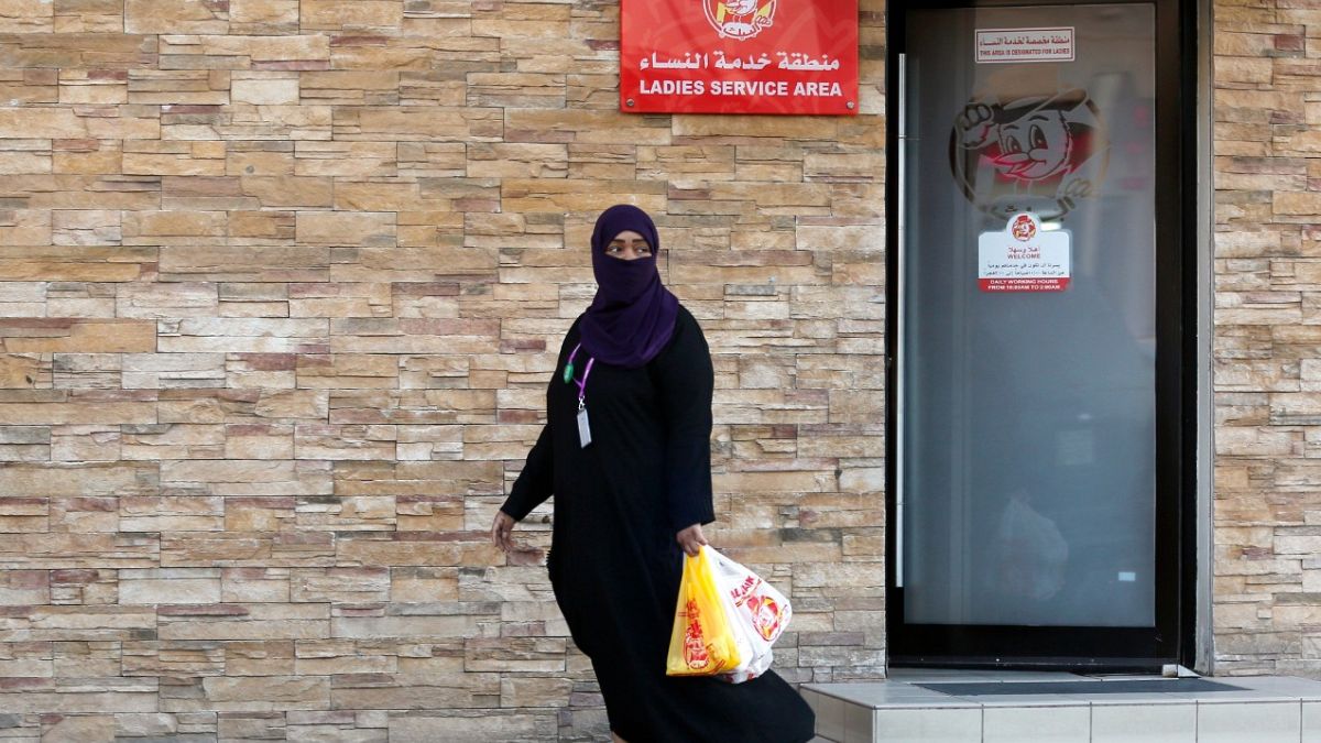 امرأة تغادر منطقة خدمة للسيدات في مطعم في جدة، المملكة العربية السعودية