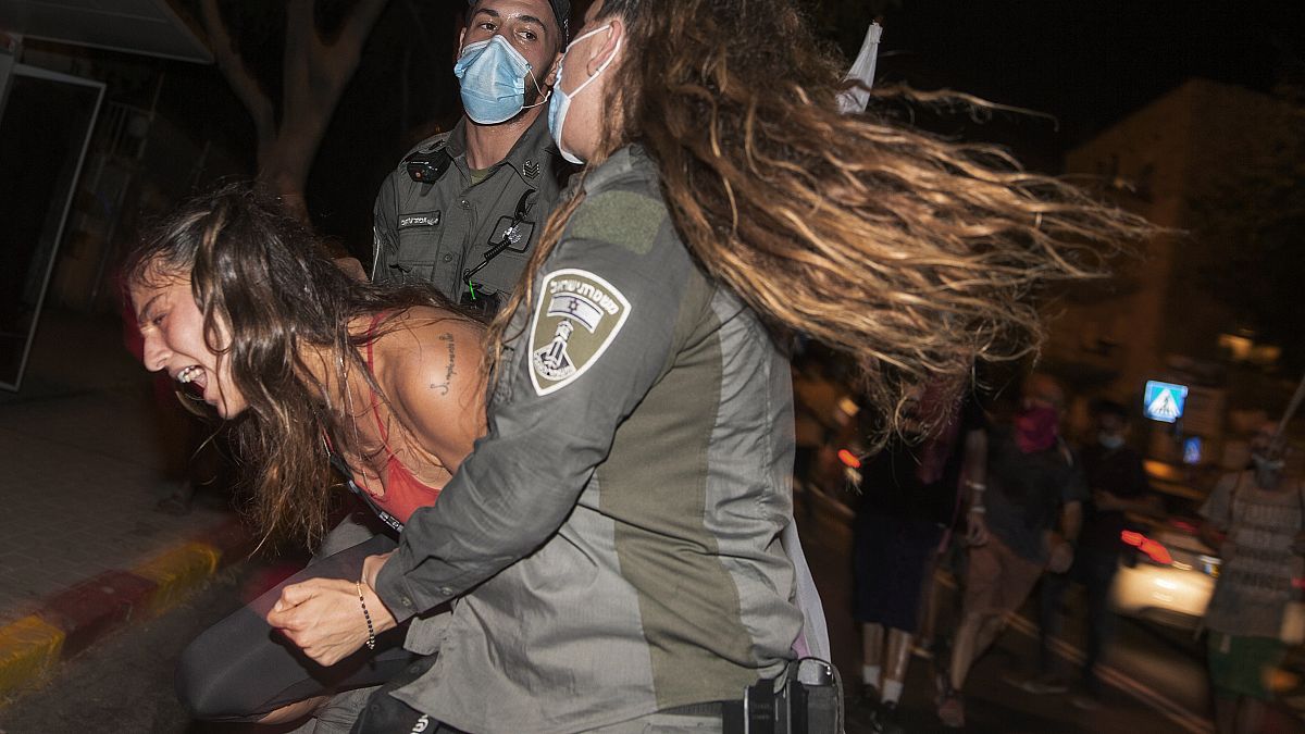پلیس یکی از معترضان را در نزدیکی اقامتگاه بنیامین نتانیاهو  در بیت‌المقدس بازداشت می‌کند