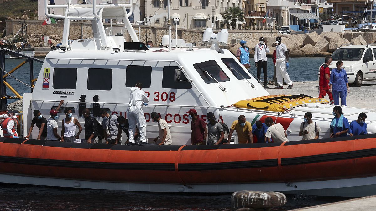 Los migrantes abordan un barco de la Guardia Costera italiana que los llevará al ferry GNV Rhapsody amarrado en la isla de Lampedusa, Italia, el 5 de septiembre de 2020.