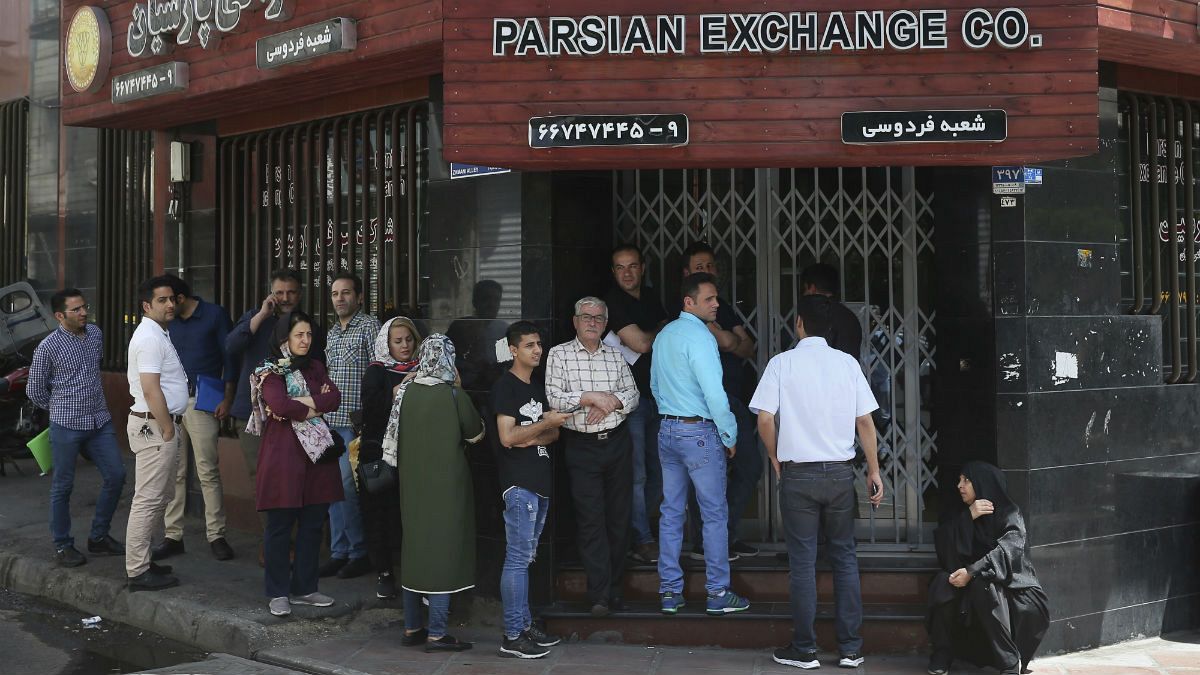 People line up in front of a currency exchange shop to buy U.S. dollars and euros, in downtown Tehran, Iran 