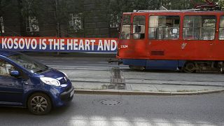 A tram car passes by a billboard reading: ''Kosovo is the heart and soul of Serbia'' placed on a street in front of the government building in Belgrade, Serbia, Sept. 2, 2020.