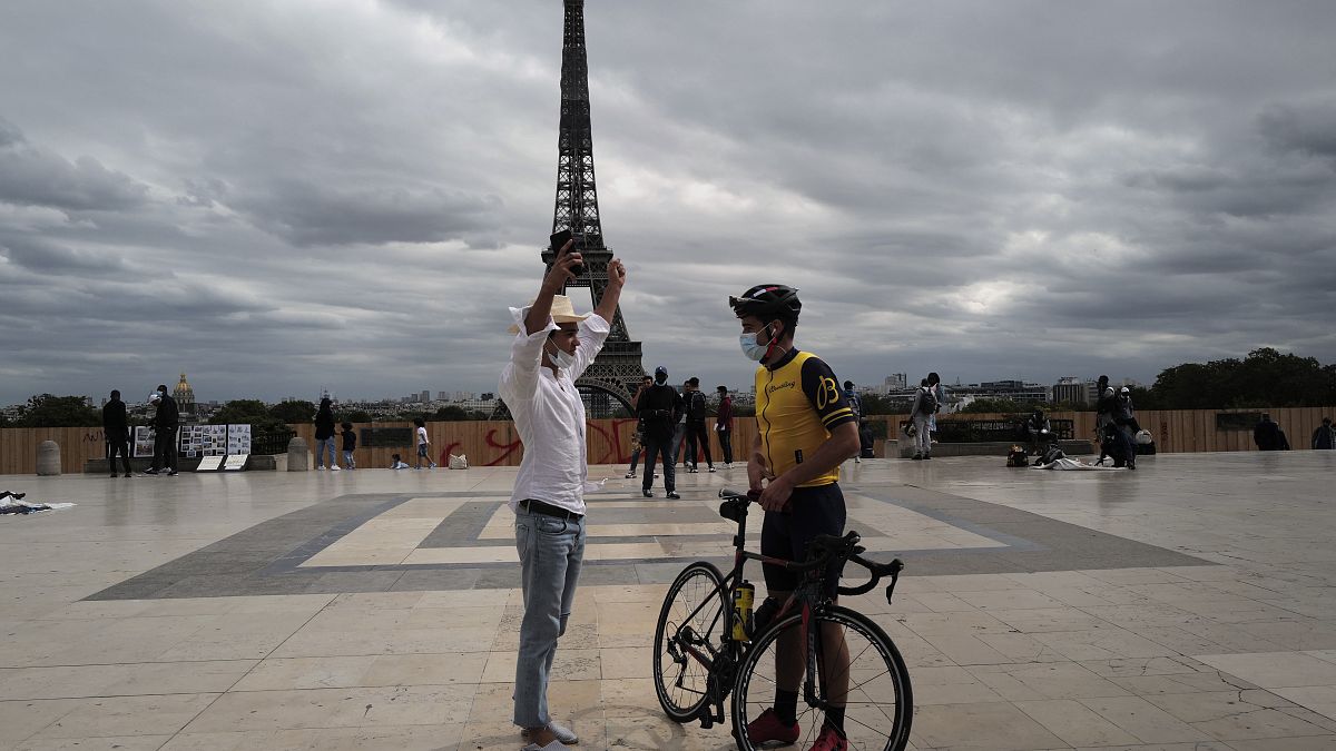 Dos hombres con mascarilla charlan frente a la Torre Eiffel, en París, el sábado 5 de septiembre de 2020. 