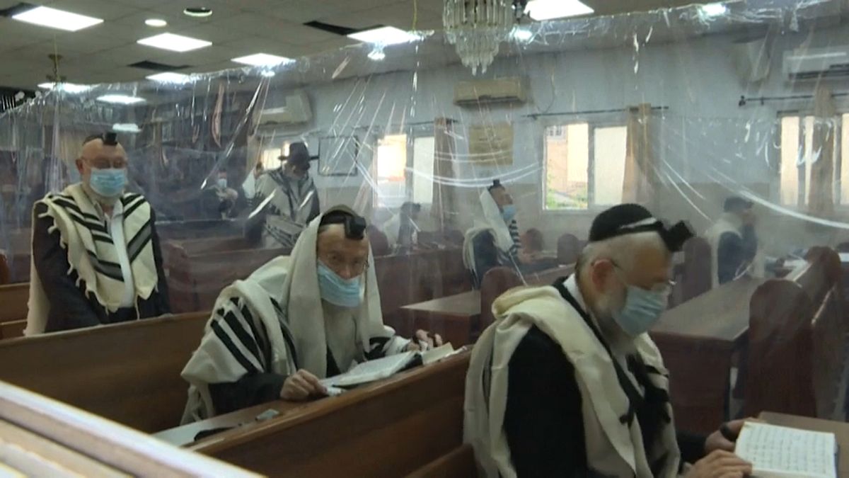 يهود متدينون يؤدون الصلاة مع احترام القيود التي فرضتها جائحة كورونا. المكان بلدة بني براك في إسرائيل 