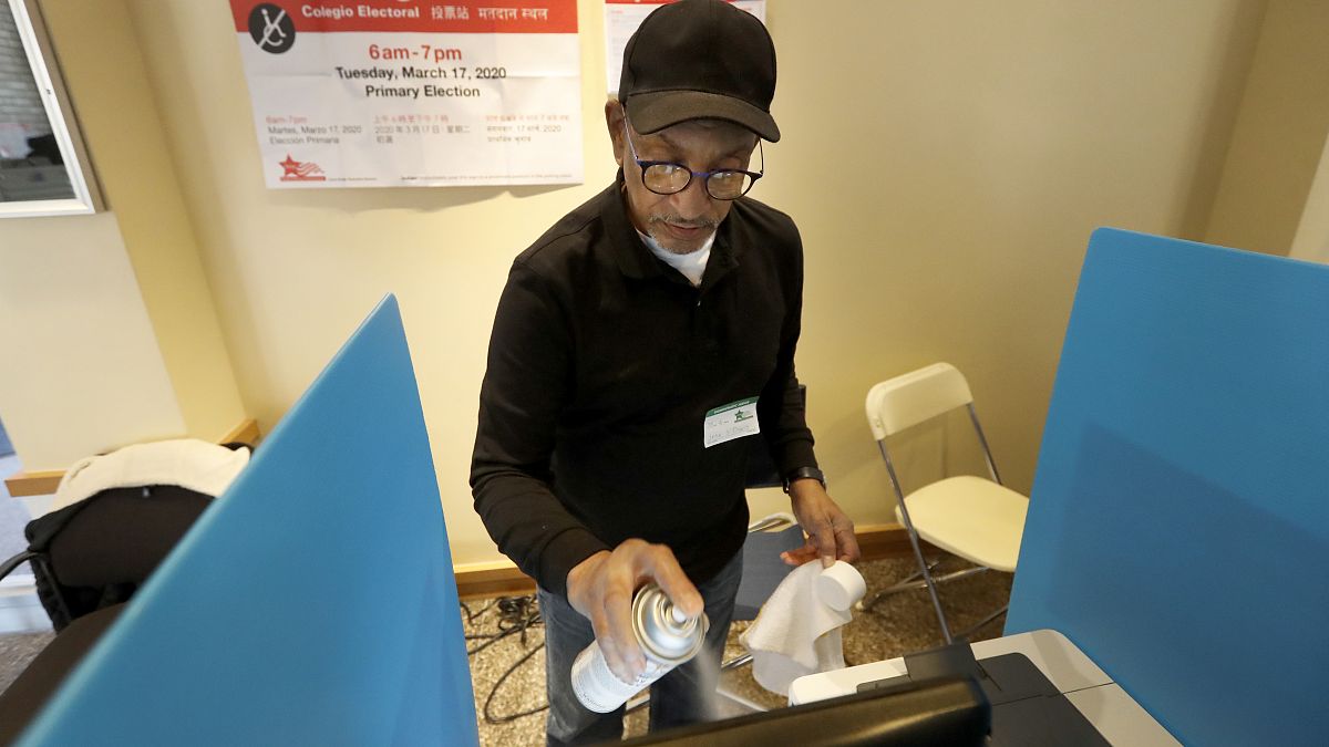 متطوع يطهر شاشة آلة تضويت إلكترونية وسط مخاوف من فيروس في مركز اقتراع في شيكاغو. 2020/03/17 