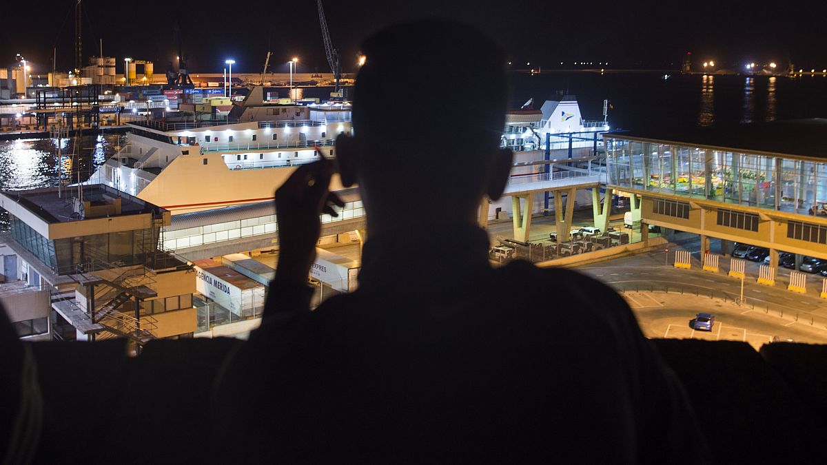 Un senzatetto marocchino guarda il porto di Melilla in una sera di settembre del 2018 - Foto d'archivio