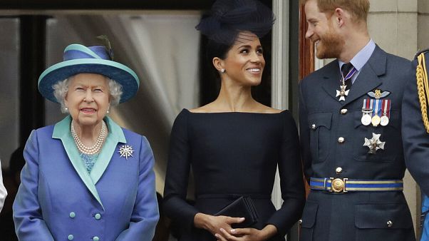 Britain's Queen Elizabeth II, Meghan and Harry watch a flypast of Royal Air Force aircraft pass over Buckingham Palace in London Britain's Queen Elizabeth II, Meghan and Harry watch a flypast of Royal Air Force aircraft pass over Buckingham Palace in London