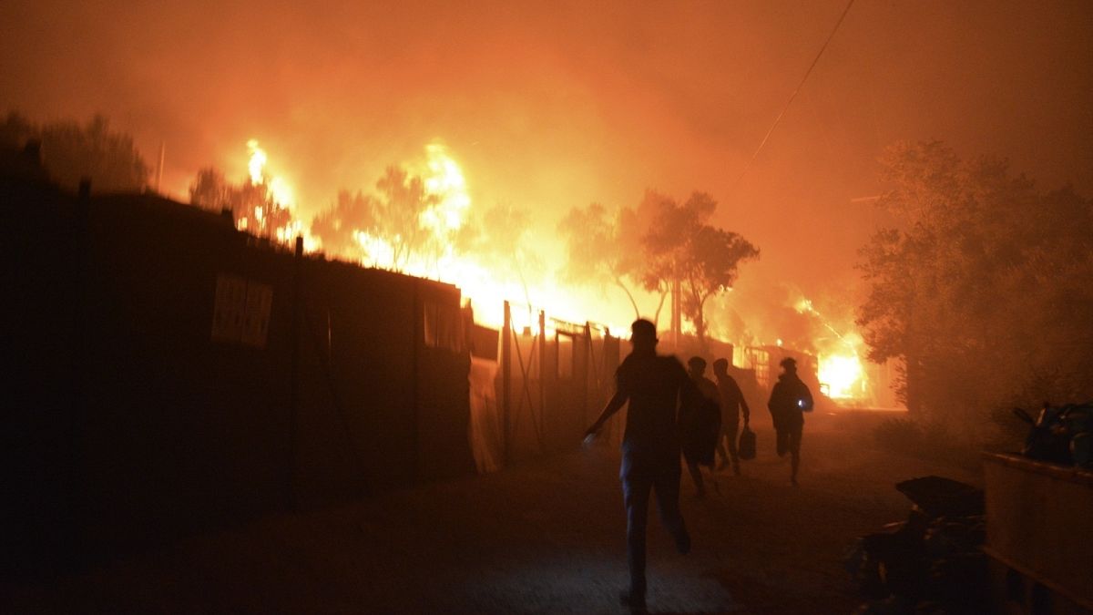لاجئون ومهاجرون يفرون من مخيم موريا للاجئين في جزيرة ليسبوس اليونانية بعد اندلاع حريق، 9 سبتمبر 2020
